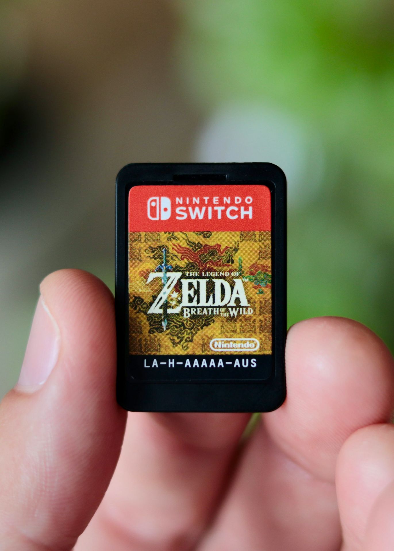 a hand holding a nintendo wii game card